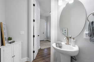 Half bath with baseboards and dark wood-style floors