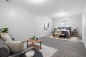 Bedroom with light colored carpet and baseboards
