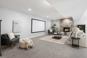 Family room with carpet flooring, a stone fireplace, and recessed lighting