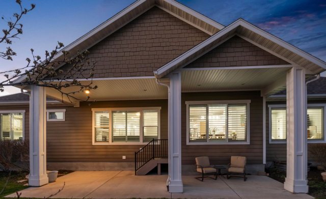 Back of property at dusk featuring a patio