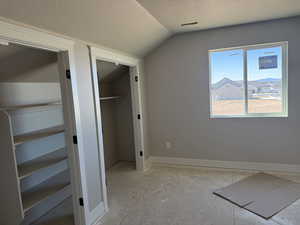 Unfurnished bedroom with baseboards and a walk in closet
