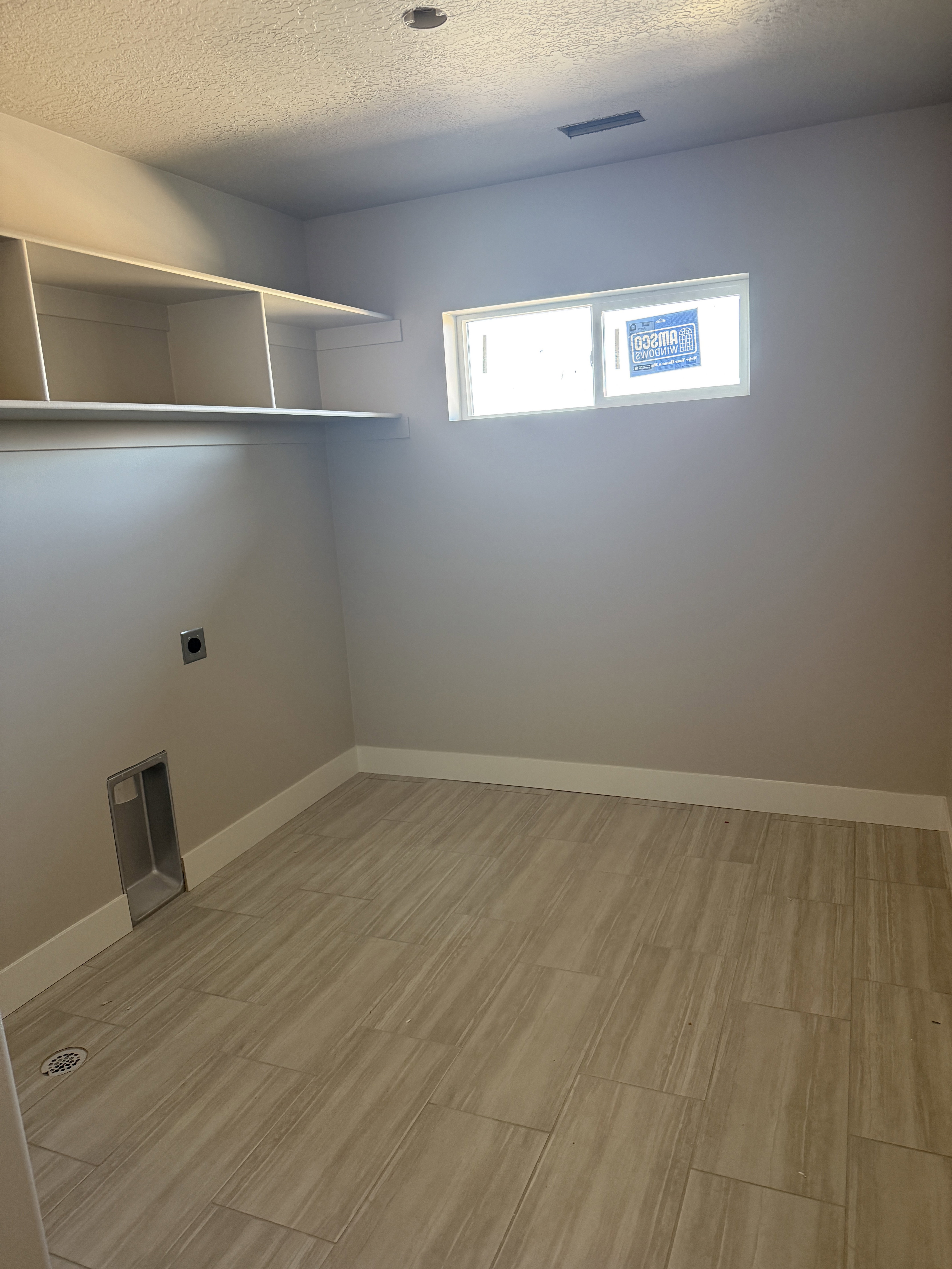 Laundry area featuring a textured ceiling, hookup for an electric dryer, and light wood-type flooring