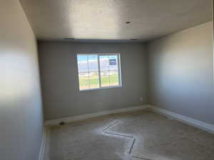 Unfurnished room with a textured ceiling