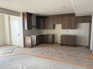 Kitchen with dark wood finish cabinetry and a textured ceiling