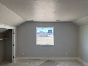Additional living space featuring a textured ceiling and baseboards