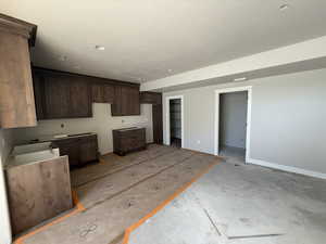 Kitchen featuring dark wood finish cabinets and a textured ceiling