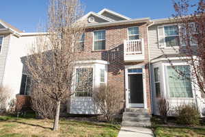 View of front of home featuring entry steps, brick siding, and a front lawn