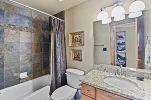 Bathroom featuring vanity and shower / bathtub combination with curtain