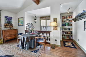 Dining room with hardwood / wood-style floors and lofted ceiling with beams