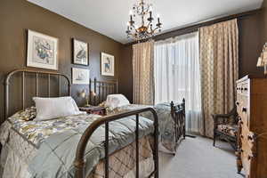 Carpeted bedroom featuring suspended lighting