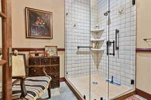 Full bath featuring a shower stall and stone finish floors