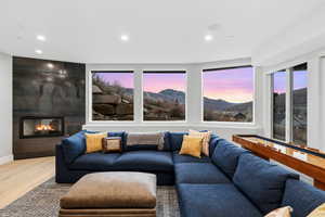 Living room with a mountain view, recessed lighting, a fireplace, and wood finished floors