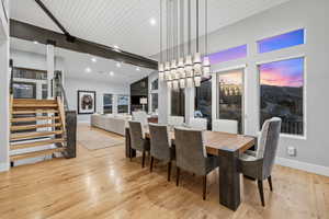 Dining area with light wood-style floors and hanging lights
