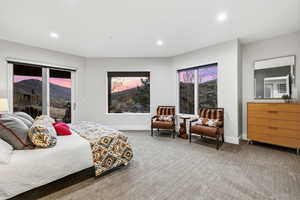 Bedroom featuring a mountain view, access to exterior, light colored carpet, and recessed lighting