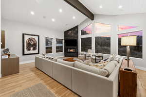 Living room featuring light wood finished floors, a large fireplace, and recessed lighting