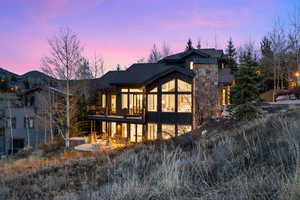 Back of house at dusk with a patio area and board and batten siding