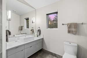 Half bathroom with vanity and dark tile patterned floors