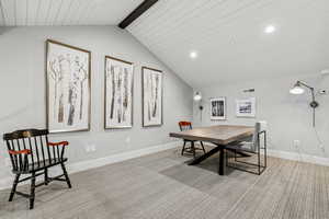 Carpeted dining area with recessed lighting and beam ceiling