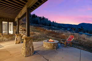 Patio terrace at dusk with a patio, an outdoor fire pit, and a mountain view