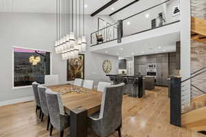 Dining space featuring light wood-style flooring, vaulted ceiling, and recessed lighting