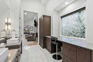 Full bathroom with double vanity, light marble finish floors, and recessed lighting