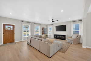 Living area featuring ceiling fan, light wood-style flooring, plenty of natural light, and recessed lighting