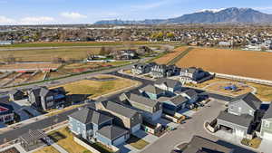 Aerial view of property and surrounding area featuring nearby suburban area and a mountainous background