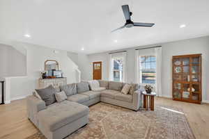 Living room with light wood-style floors, ceiling fan, and recessed lighting