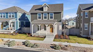 View of front of house featuring covered porch, a gate, roof with shingles, and a residential view