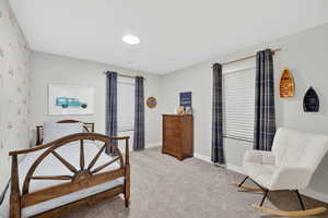 Bedroom with light colored carpet and baseboards