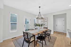 Dining area with light wood finished floors and a chandelier
