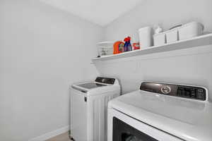 Laundry area featuring washer and clothes dryer and light wood-style floors