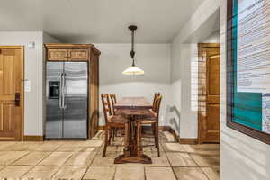 Dining space with stone tile flooring and baseboards