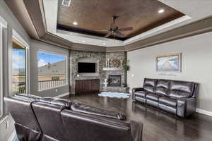 Living room with a ceiling fan, dark wood-style flooring, a fireplace, and recessed lighting