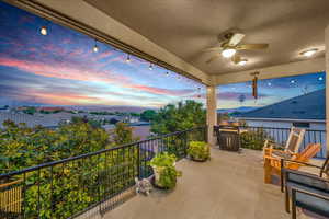 Balcony at dusk with a patio, area for grilling, and a ceiling fan