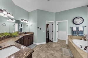 Full bathroom featuring double vanity and a garden tub
