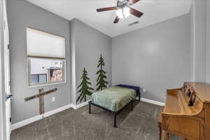 Bedroom with dark colored carpet and a ceiling fan