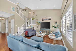Living area with a chandelier, a high ceiling, and wood-type flooring