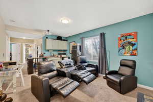 Living area featuring light colored carpet and baseboards