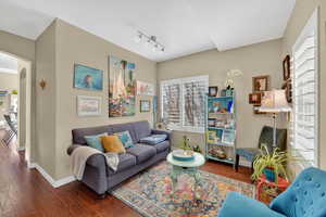 Living room featuring hardwood / wood-style floors, arched walkways, and rail lighting