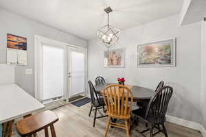 Dining area featuring suspended lighting, light wood-style floors, and a textured ceiling
