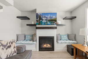 Living room featuring a glass covered fireplace, wood finished floors, and a textured ceiling
