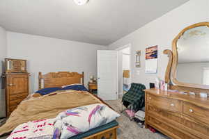 Bedroom with light carpet and a textured ceiling