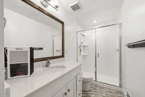 Bathroom featuring vanity and a stall shower