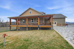 View of front of home featuring covered porch, a mountain view, stone siding, and a patio area