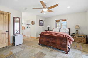Bedroom with stone tile floors, ceiling fan, and recessed lighting