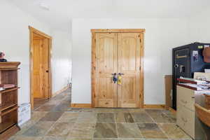 Home office featuring stone tile floors and baseboards