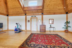 Sitting room with wood-type flooring and a high wooden beamed ceiling