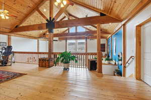 Recreation room featuring a ceiling fan, a high wood beamed ceiling, and hardwood / wood-style floors