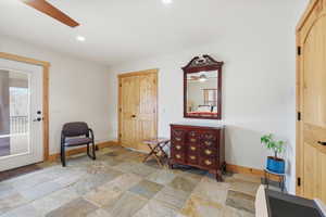 Living area featuring a ceiling fan, stone tile flooring, and recessed lighting